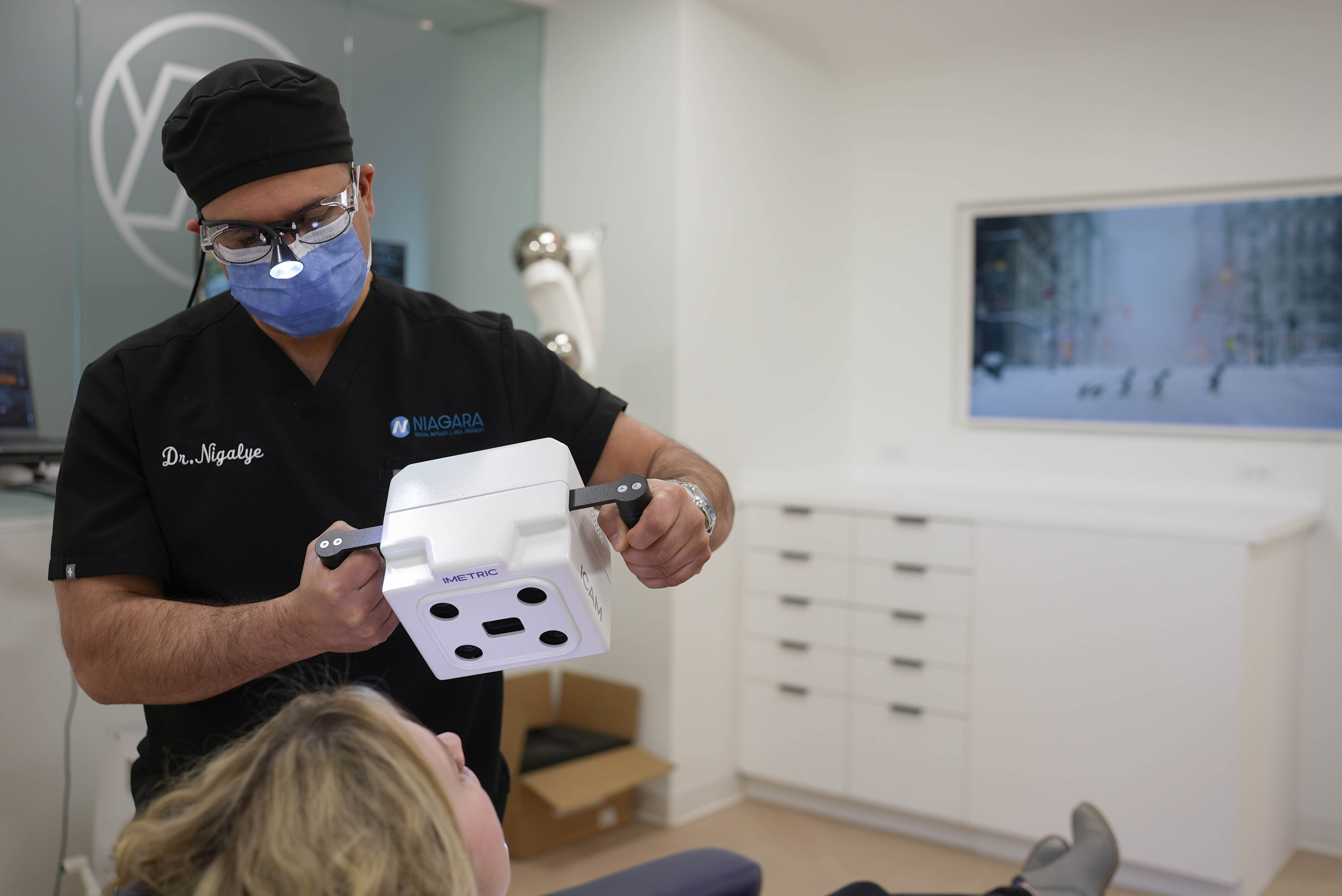 Dr. Nigalye using digital scanning technology on a patient